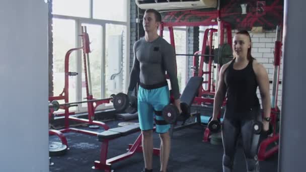 Svalnatá žena a její trenér dělá Curl s činky cvičení v posilovně — Stock video
