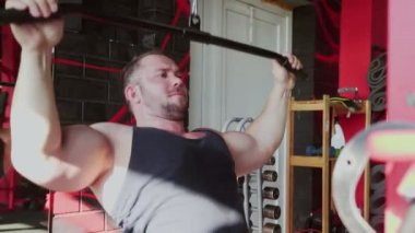 Çekici bir vücut geliştirme ustası spor salonunda Lat-down yapıyor.