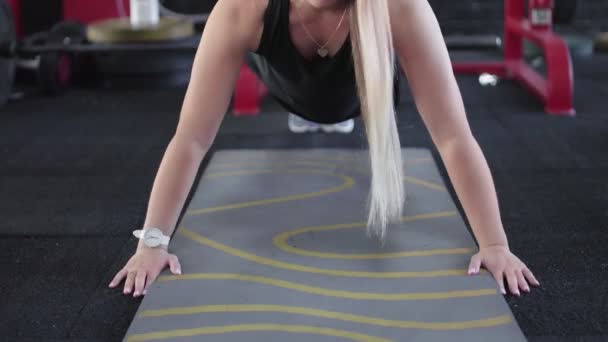 Jong blond vrouw doet push-up oefening in sportschool — Stockvideo