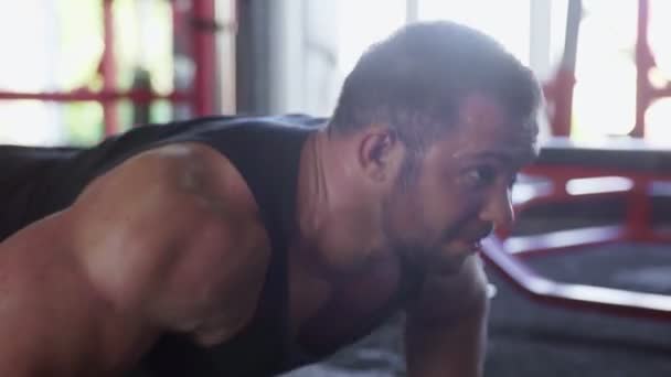 Un hombre atractivo culturista realizando ejercicio push-up en el gimnasio — Vídeos de Stock