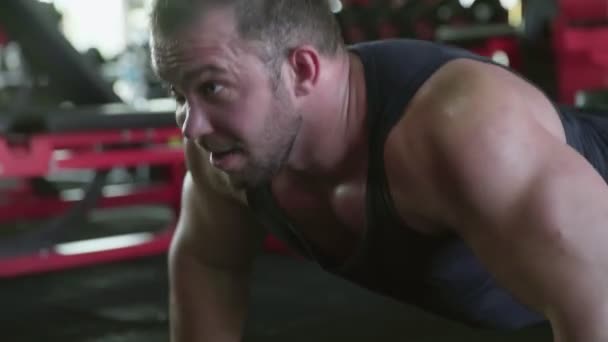 Um homem atraente fisiculturista realizando exercício Push-up no ginásio — Vídeo de Stock