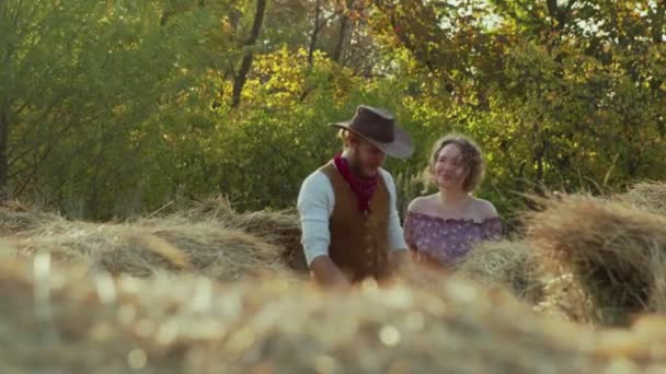 Giovane cowboy e la sua ragazza cammina attraverso fieno in fattoria — Video Stock