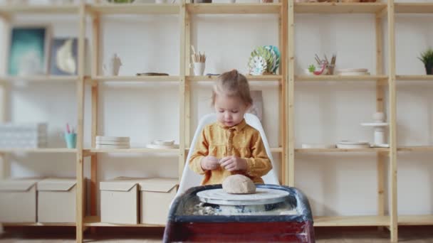 Kleine Mädchen spielen, wie Töpfer einen Topf auf der Töpferscheibe macht — Stockvideo