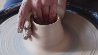 Beyaz kil yakın plan vazo oluşturuluyor. Atölyedeki heykeltraş kilden sürahi yapıyor. Çarpık çömlekçi