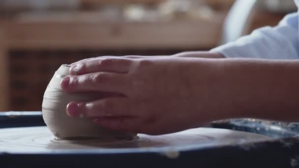 Seitenansicht der kleinen Jungen Hände arbeiten an der Töpferscheibe und formen einen Tontopf — Stockvideo