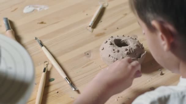 Vista posterior de niño juega con arcilla en la clase de cerámica — Vídeo de stock