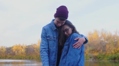 Romantik Kafkasyalı genç çift sonbahar parkında sarılıyor.