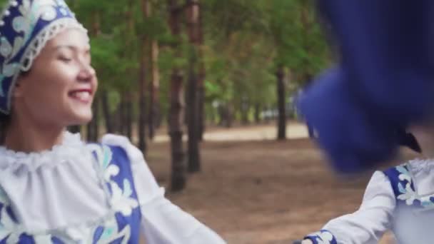 Großaufnahme von sechs jungen Frauen in traditionellen russischen Trachten, die im Sommerwald tanzen — Stockvideo