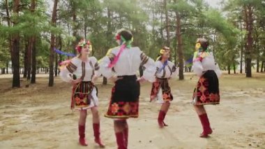 Geleneksel kostümlü genç kadınlar Ukrayna ulusal danslarında dans ediyorlar.