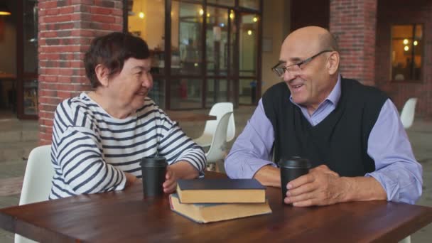 Pareja mayor tomando té o café en un café de la calle. — Vídeos de Stock