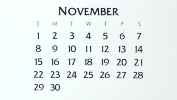 赤いマーカーでカレンダー日付の女性の手の円の日。ビジネスの基本壁カレンダープランナーと主催者。11月5日 — ストック動画