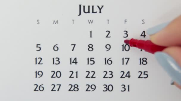 Vrouwelijke handcirkeldag in kalenderdatum met een rode stift. Business Basics Wall Calendar Planner en Organisator. 10 juli — Stockvideo