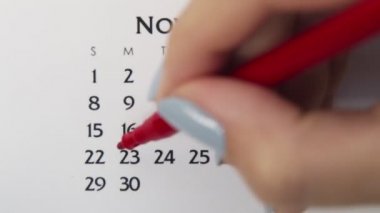 Takvimde kırmızı kalemli bir kadın el çemberi günü. İş Temel Duvar Takvimi Planlayıcı ve Düzenleyici. 23 Kasım