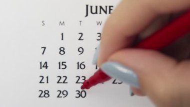 Takvimde kırmızı kalemli bir kadın el çemberi günü. İş Temel Duvar Takvimi Planlayıcı ve Düzenleyici. 30 Haziran