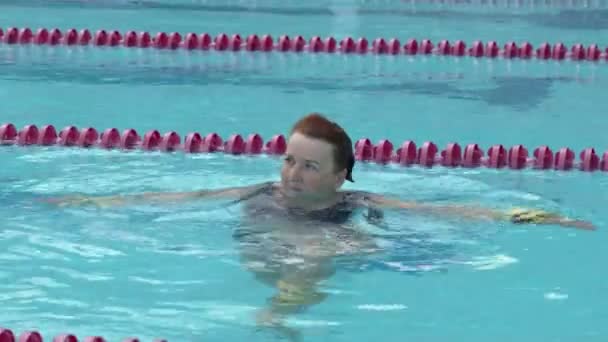 Een oude dame training aqua gymnastiek in het zwembad. — Stockvideo