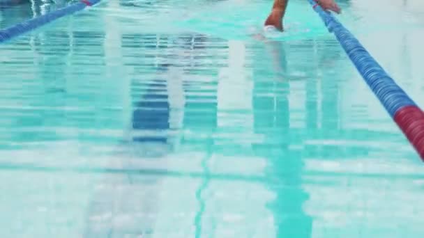 Nageur professionnel à peine travailler dans la piscine intérieure de natation à travers la piste. — Video