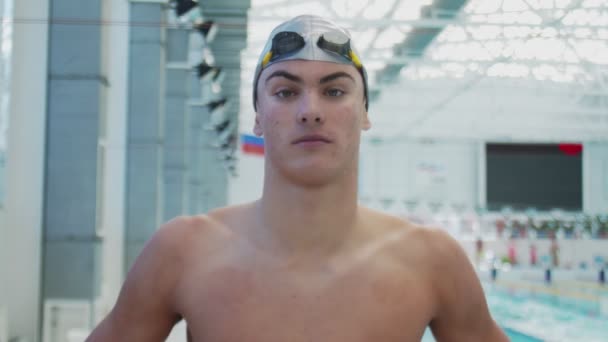 Smuk atlet svømmer ser på kameraet – Stock-video