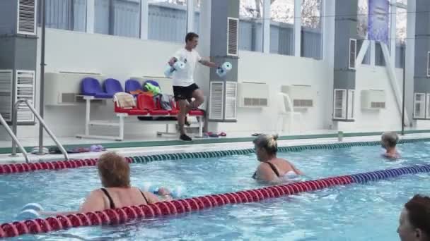 Ausbilder trainiert Wassergymnastik für Frauen im Schwimmbad. — Stockvideo