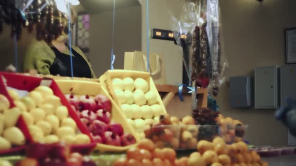 女性の売り手は、顧客の女性に果物と紙袋を与えます — ストック動画