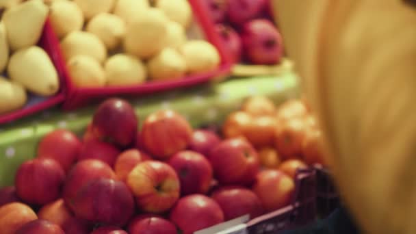 Gros plan de l'homme choisit une pomme rouge fraîche sur le marché — Video