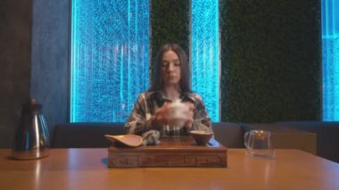 Genç kadın testlerinin ön görüntüsü Çin çayının kalitesini ve rengini ölçüyor. Geleneksel Doğu Çin çay töreni.