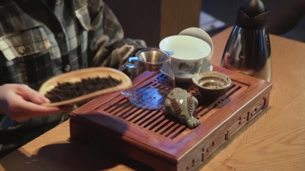 Egy fiatal nő kínai tealeveleket szippant fel tányéron. Hagyományos keleti kínai teaszertartás. — Stock videók