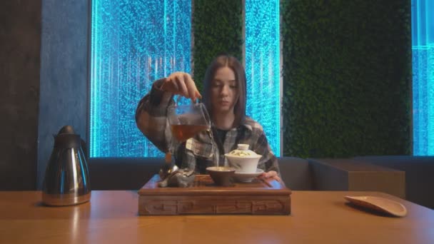 Vooraanzicht van de vrouw schenkt thee uit waterkoker te beker en drinkt het — Stockvideo