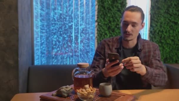 Primer plano de joven registra historias en su teléfono en la cafetería de té chino — Vídeos de Stock