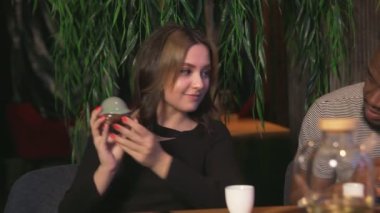 Genç kadın Çin çay kafesindeki seramik Çin çay kurbağasını inceliyor.