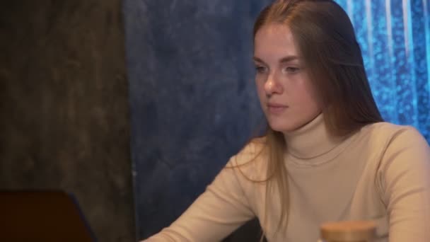 Giovane donna lavora dietro notebook mentre seduto in un caffè. — Video Stock
