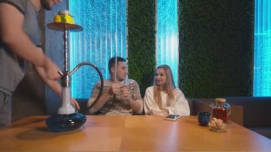 Genç çift Shisha salonundaki nargilede rahatlar ve sigara içer.