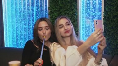 En iyi iki kız arkadaş nargile barında selfie çeker.