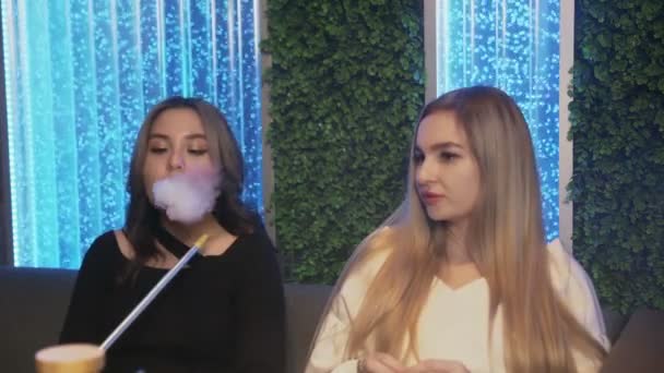 Deux amies au bar du narguilé. une femme offre de fumer, une autre refuse — Video