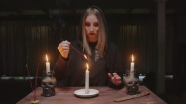 Genç cadı kadın falcı gelecek için mum ve tütsü kullanıyor.
