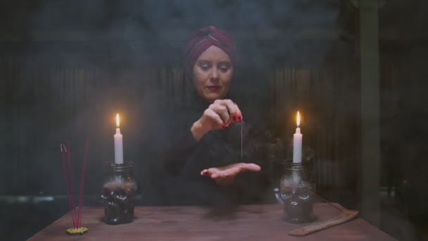 Starší žena věštkyně používá jehlu s nití na magické věštění rituál — Stock video