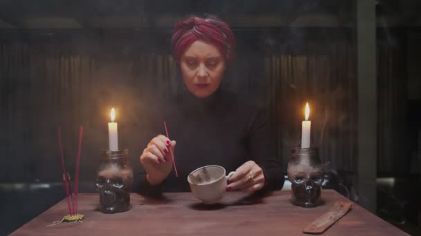 Senior bruxa cartomante mulher está segurando xícara de café e leitura destino — Vídeo de Stock