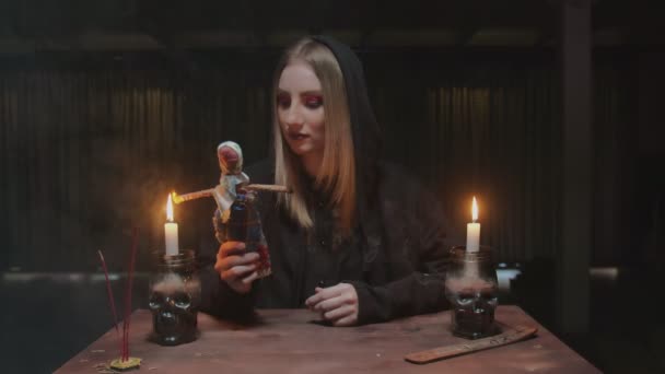 Jovem bruxa cartomante feminino incendeia as mãos da boneca vodu em terrível ritual mágico — Vídeo de Stock