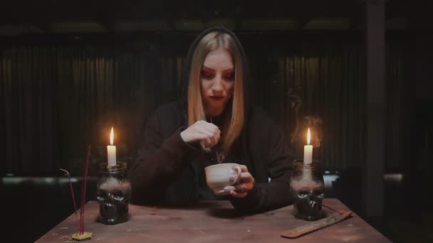 Jovem bruxa fêmea cartomante é segurando xícara de café e leitura destino — Vídeo de Stock