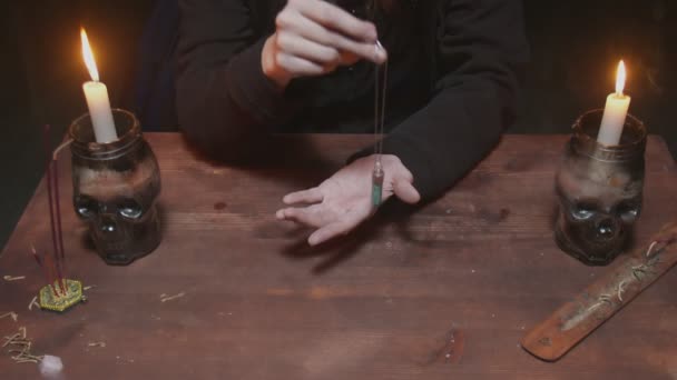 Close up de jovem bruxa cartomante usa um cristal mágico azul e sua mão em ritual místico — Vídeo de Stock