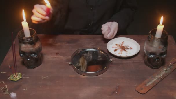 Close-up de bruxa cartomante feminino derrama arroz no espelho e pintado cruz sobre ele em terrível ritual mágico — Vídeo de Stock