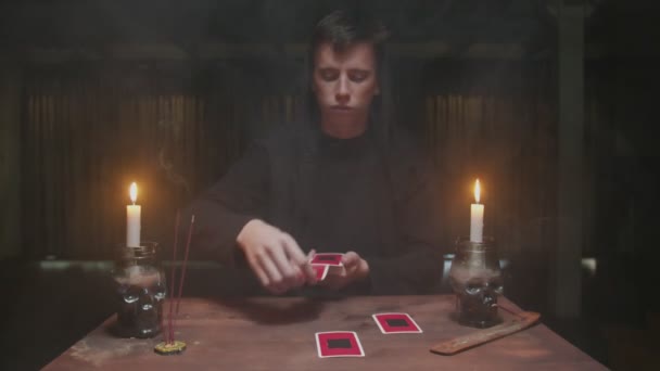 Feiticeiro misterioso concentrado cartomante masculino colocando cartões em ordem como rito místico, em seguida, rodá-los e ler o futuro. — Vídeo de Stock