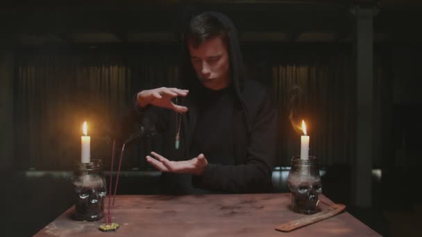 Concentrated mysterious wizard male fortune teller uses a blue magic crystal to future telling ritual — Stock Video