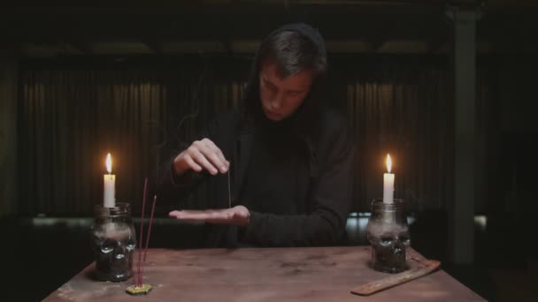 Koncentrerad mystisk trollkarl manlig spåkvinna använder nål med tråd till magisk spådom ritual — Stockvideo
