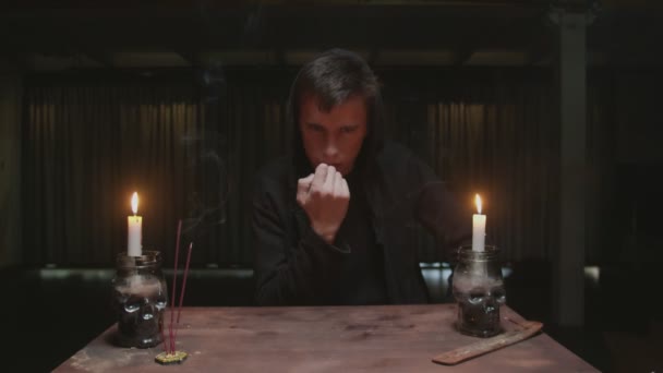Skoncentrowany tajemniczy czarodziej męski wróżbita używa kości do rytuału wróżenia magii — Wideo stockowe