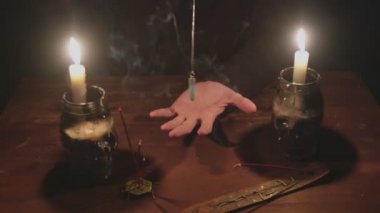Gizemli büyücü erkek falcıya yakın çekim. Gelecekteki ayinlerinde mavi sihirli kristal kullanıyor.