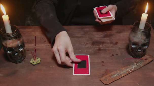 Крупный план загадочного волшебника мужского предсказателя использует карту Таро и телефон, чтобы читать будущее — стоковое видео