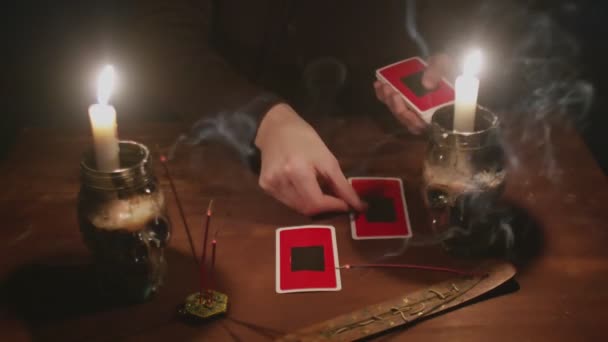 Close up of mysterious wizard male fortune teller uses tarot card and phone to read future — Stock Video