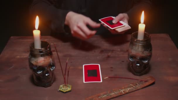 Close up of mysterious wizard male fortune teller uses tarot card and phone to read future — Stock Video