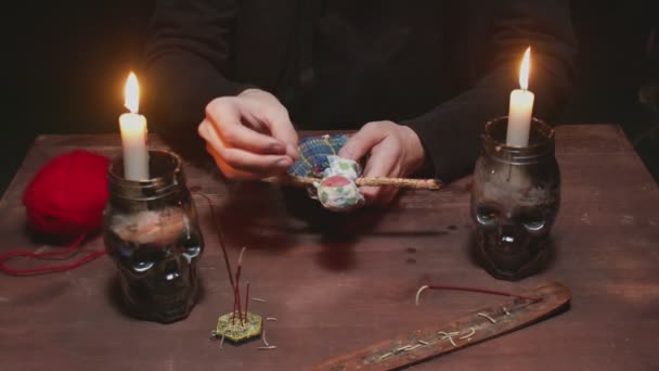 Detailní záběr tajemného čaroděje muž věštec připíchne jehlu do voodoo panenky v hrozném magickém rituálu — Stock video