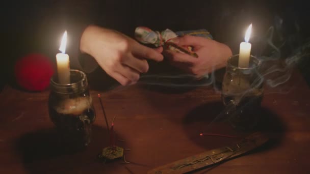 Primo piano del misterioso mago indovino maschio utilizza bambola voodoo e corda rossa per terribile rituale magico nel buio — Video Stock